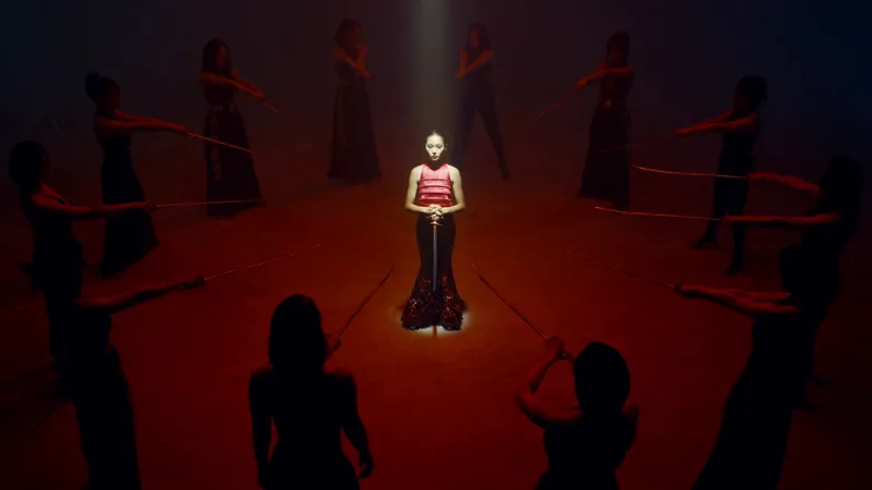 A tense, theatrical tableau: a 20-year-old East Asian woman…
